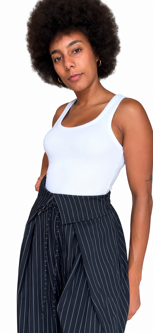Modelo luciendo pantalón A F R A A T E L I E R de raya diplomática, pierna ancha, cintura alta cruzada y lazada.