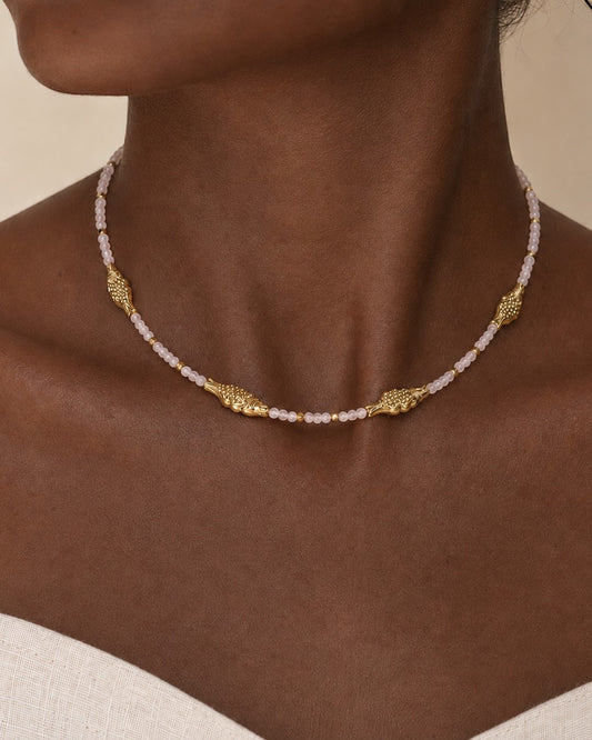 Collar Caleta de A F R A A T E L I E R con cuentas facetadas rosa claro y detalles de peces dorados en acero inoxidable