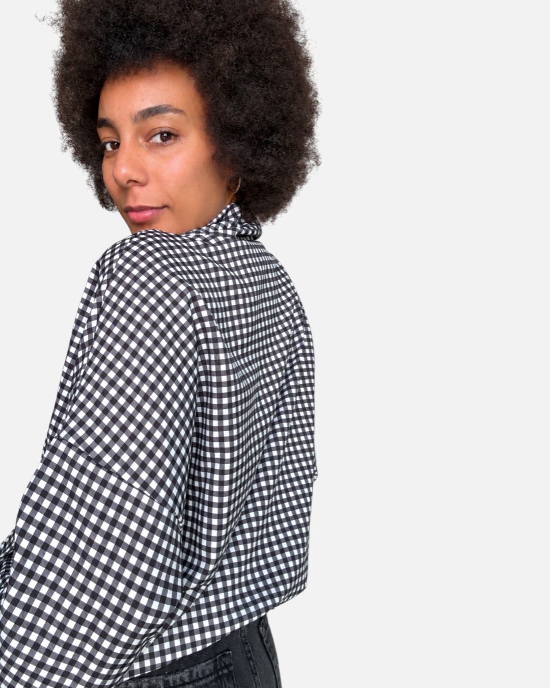 Modelo posando de espaldas con chaqueta A F R A A T E L I E R Kaia de cuadros negros y blancos con corte amplio