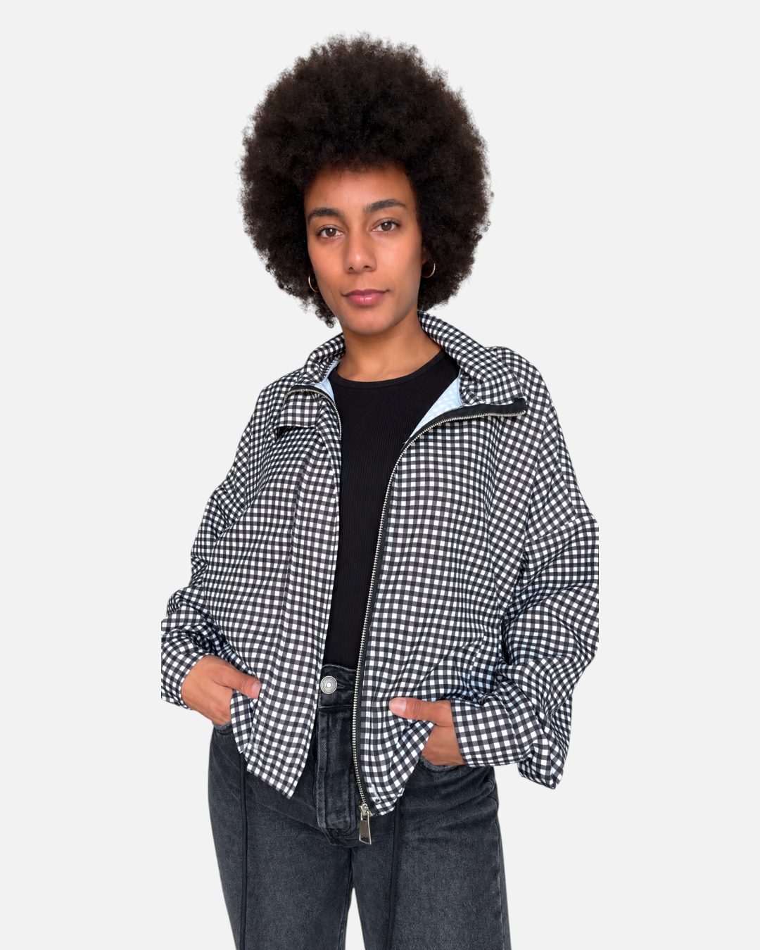 Modelo vistiendo chaqueta A F R A A T E L I E R Kaia negra de cuadros con cremallera y bajo ajustable
