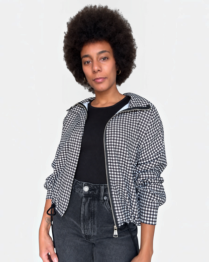 Modelo vistiendo chaqueta A F R A A T E L I E R Kaia negra de cuadros con cremallera y bajo ajustable