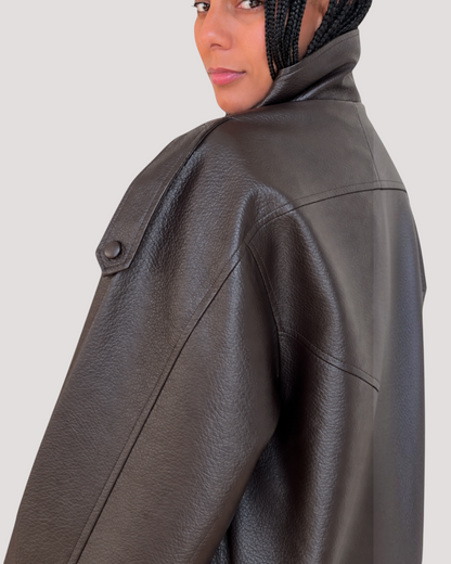 Modelo con chaqueta de poliuretano marrón de A F R A A T E L I E R con detalle de hombrera y cuello alto