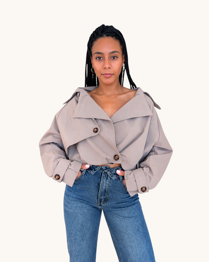 Mujer vistiendo una chaqueta bomber color topo de AFRA ATELIER con solapas anchas y botones oscuros