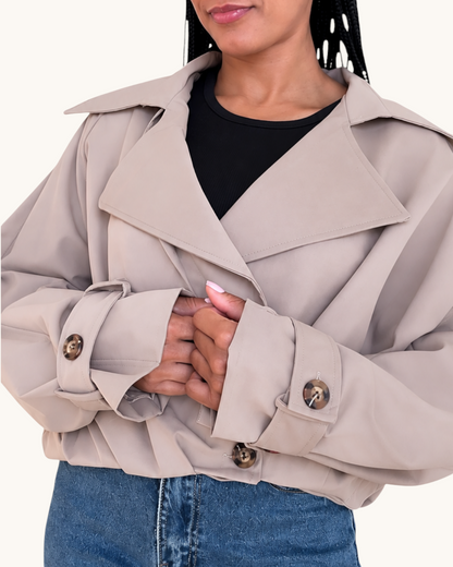 Mujer vistiendo la chaqueta Bomber Topo de AFRA ATELIER en color beige con solapas anchas y botones marrones