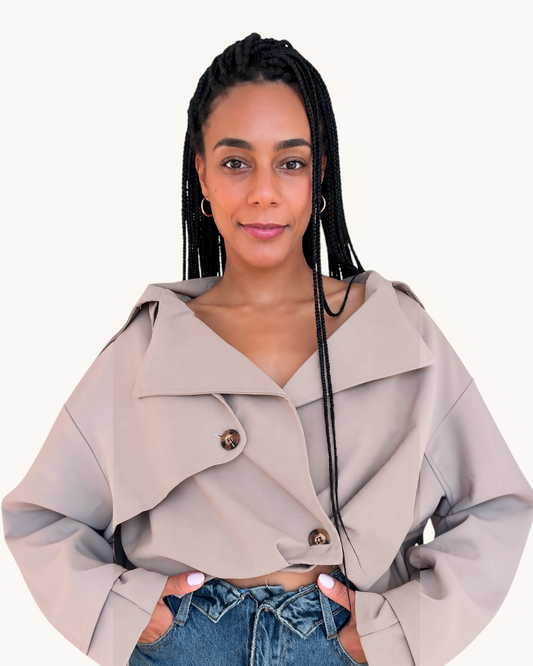Mujer con trenzas vistiendo la chaqueta Bomber Topo de AFRA ATELIER en color beige con botones oscuros