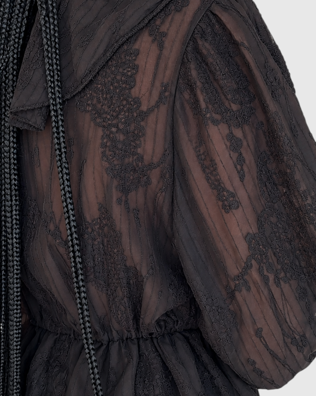 Modelo con blusa negra de encaje transparente AFRA ATELIER con cuello estilo marinero y cintura ajustada