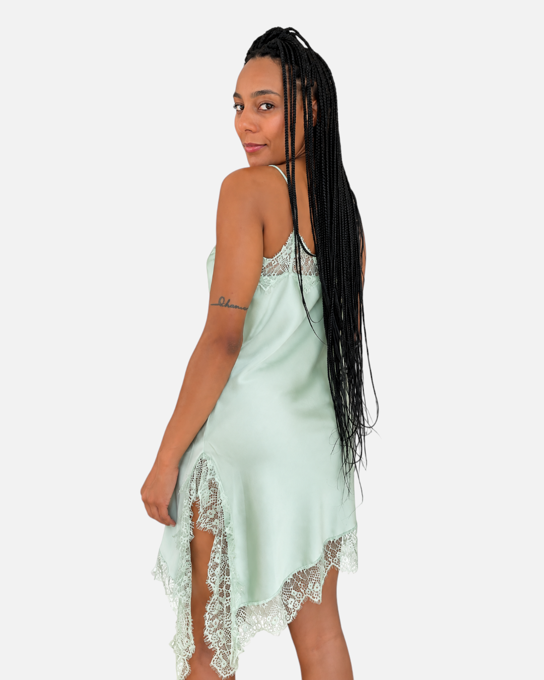 Modelo posando con vestido lencero AFRA ATELIER verde menta de satén con detalles de encaje y bajo asimétrico