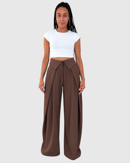 Modelo con pantalón AFRA ATELIER marrón chocolate de cintura alta, lazada frontal y corte amplio fluido.