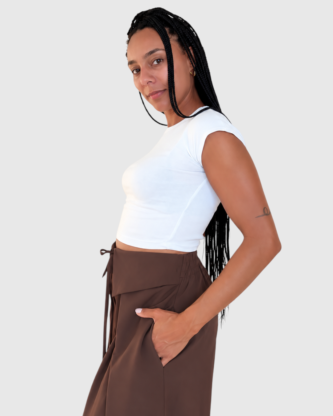 Modelo con pantalón AFRA ATELIER marrón chocolate de cintura alta con lazada frontal y corte fluido