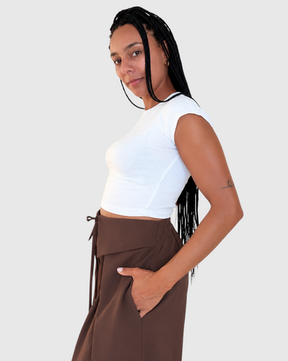 Modelo con pantalón AFRA ATELIER marrón chocolate de cintura alta con lazada frontal y corte fluido