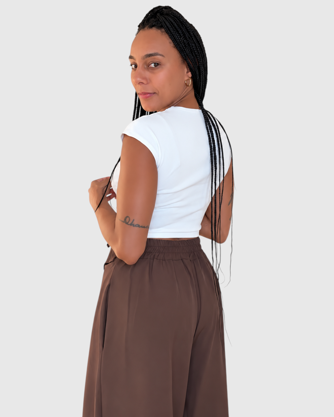 Modelo vistiendo pantalón Moka de AFRA ATELIER en marrón chocolate, diseño fluido de cintura alta con lazada frontal.