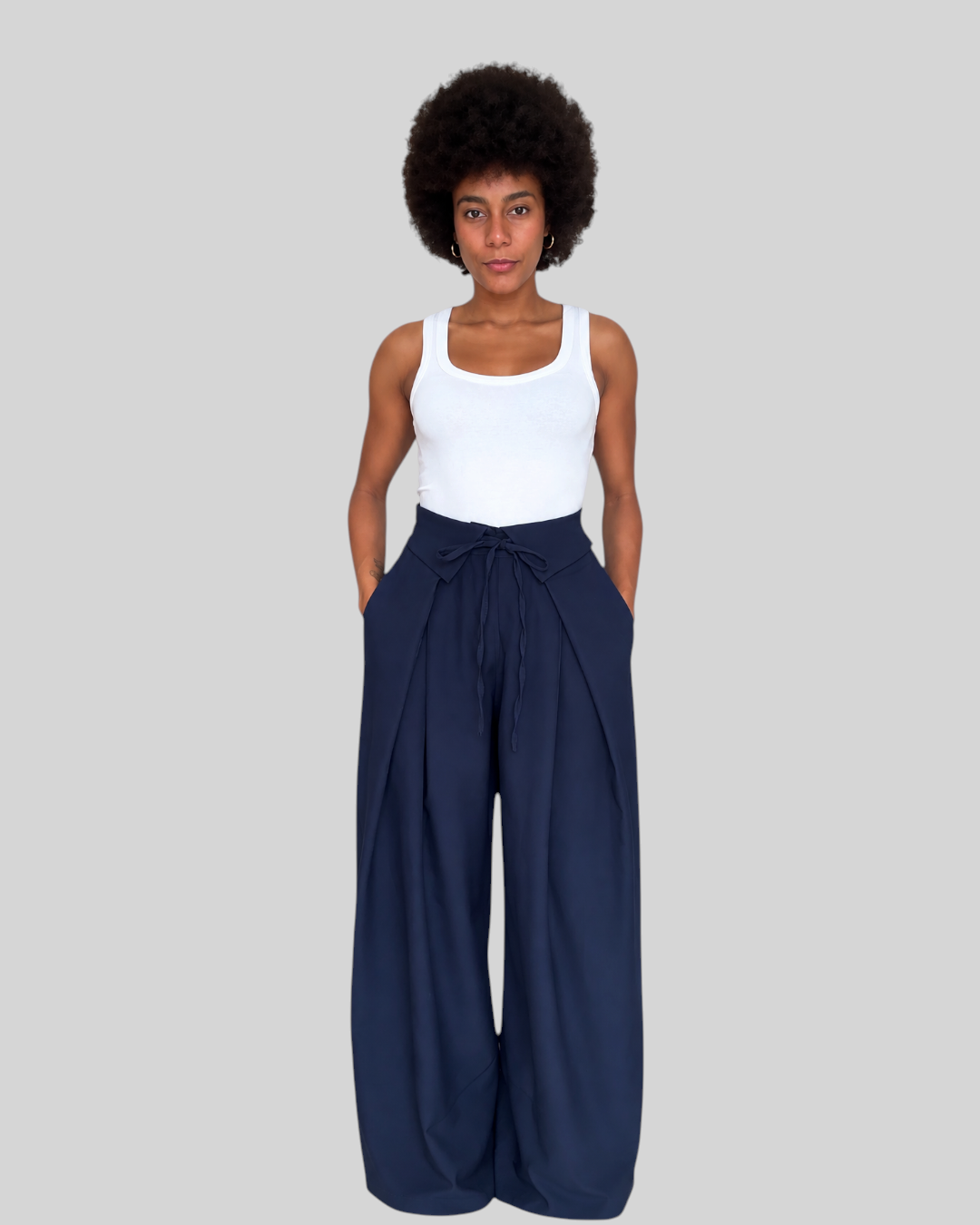 Modelo con pantalón Moka azul de A F R A A T E L I E R, corte ancho de tiro alto con lazada en la cintura.