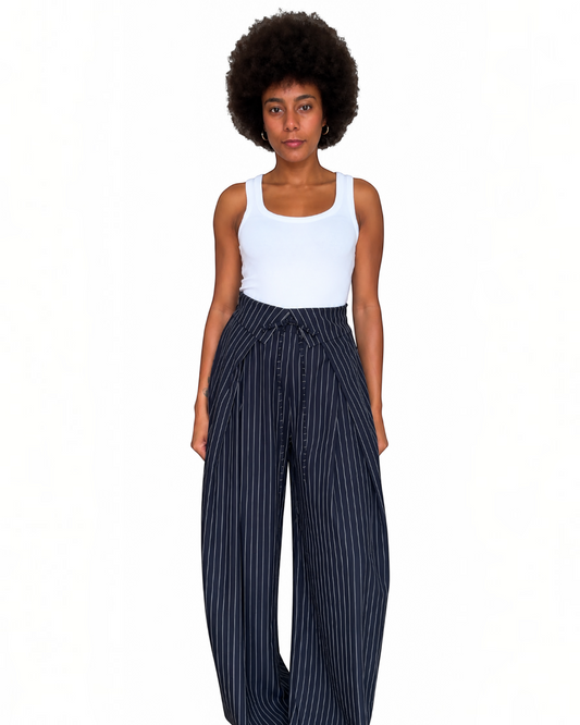 Modelo vistiendo pantalón A F R A A T E L I E R de pierna ancha, color azul marino con rayas diplomáticas y lazada