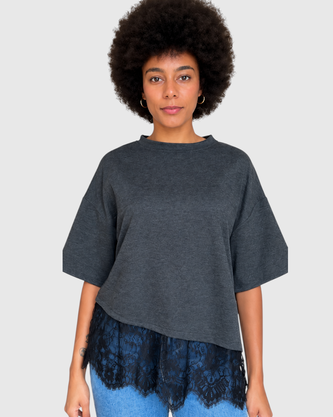 Modelo con camiseta gris A F R A A T E L I E R de corte holgado con detalle de encaje negro en el bajo