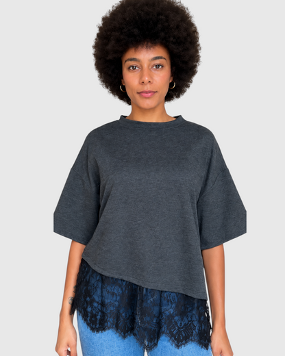 Modelo con camiseta gris A F R A A T E L I E R de corte holgado con detalle de encaje negro en el bajo