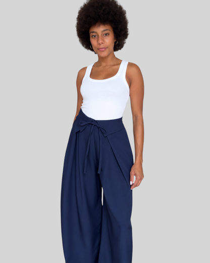 Modelo con pantalón azul marino A F R A A T E L I E R de cintura alta, lazada frontal y corte fluido