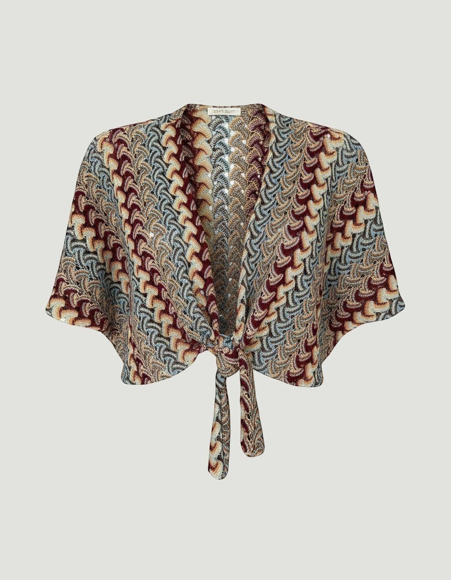 Bolero hippie de A F R A A T E L I E R en tejido de punto multicolor con patrón geométrico y cierre de nudo frontal