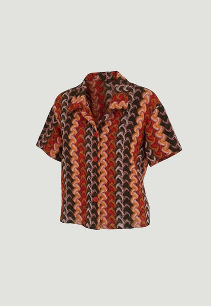 Camisa de manga corta A F R A A T E L I E R con estampado geométrico retro en tonos rojos, naranjas y marrones.
