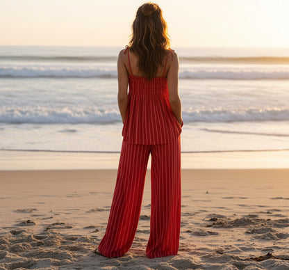 Conjunto A F R A A T E L I E R Famara de rayas rojo y rosa con top de tirantes y pantalón wide leg en la playa