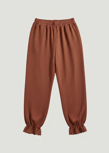 Pantalones A F R A A T E L I E R color terracota con cintura elástica y bajos con detalle de encaje floral.