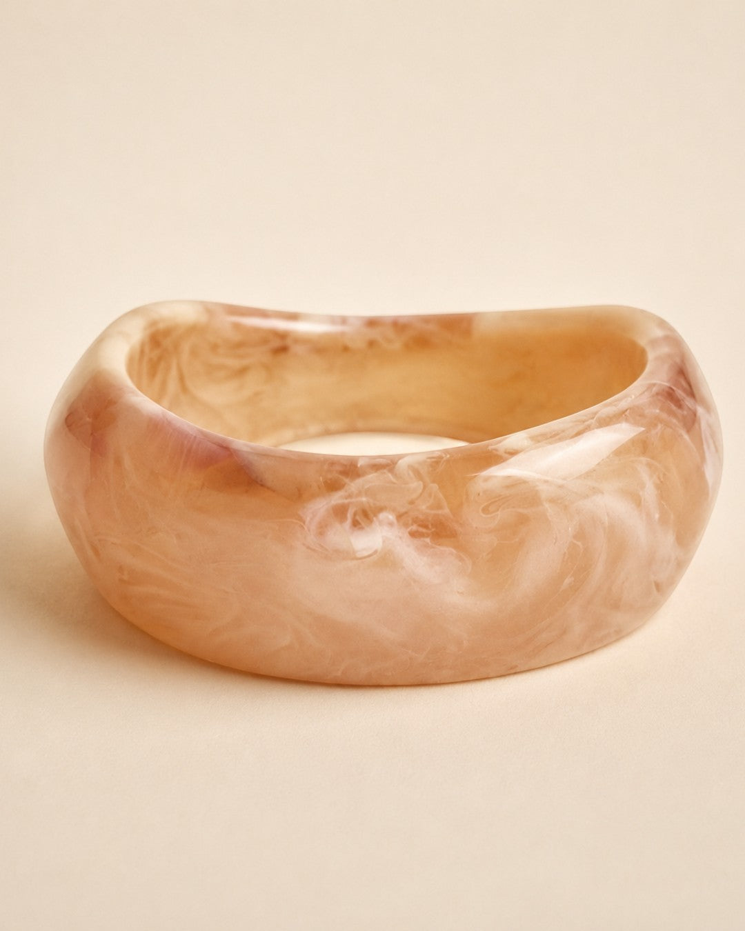 Pulsera rígida A F R A A T E L I E R con diseño ancho irregular, efecto marmoleado en tonos rosa, beige y crema.