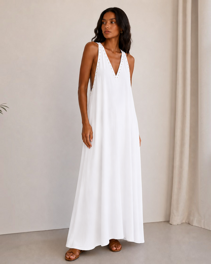 Modelo vistiendo el vestido largo blanco Solea de A F R A A T E L I E R con escote en pico y detalles metálicos