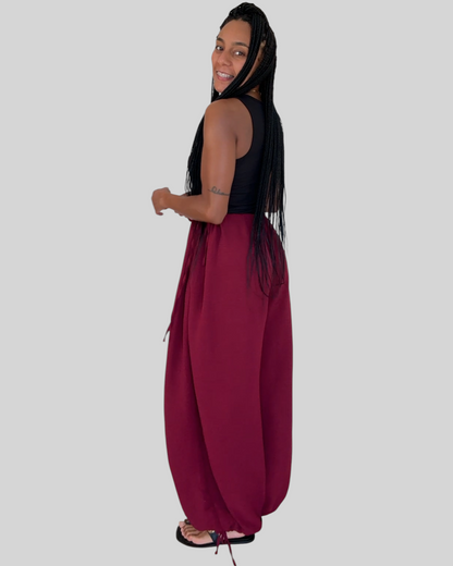 Modelo con pantalón bombacho AFRA ATELIER color burdeos de tejido fluido con lazadas ajustables en cintura y tobillos